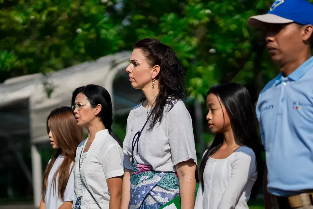 A group of people standing next to each other in a park.