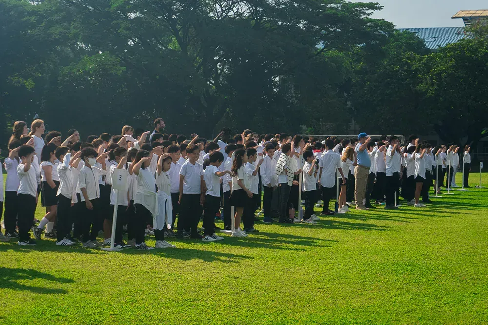 A large group of people are standing in a grassy field.