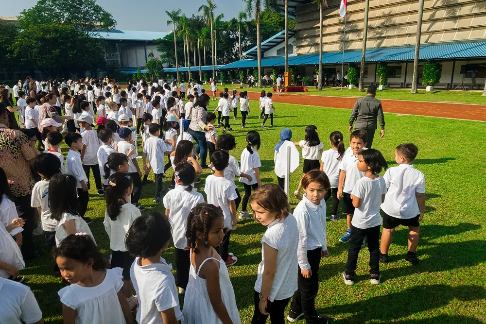 A large group of children are standing in a field.