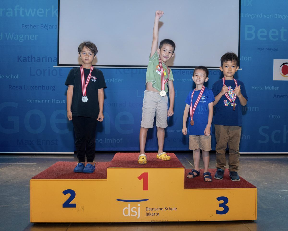 A group of young boys standing on a podium with the number 1 on it
