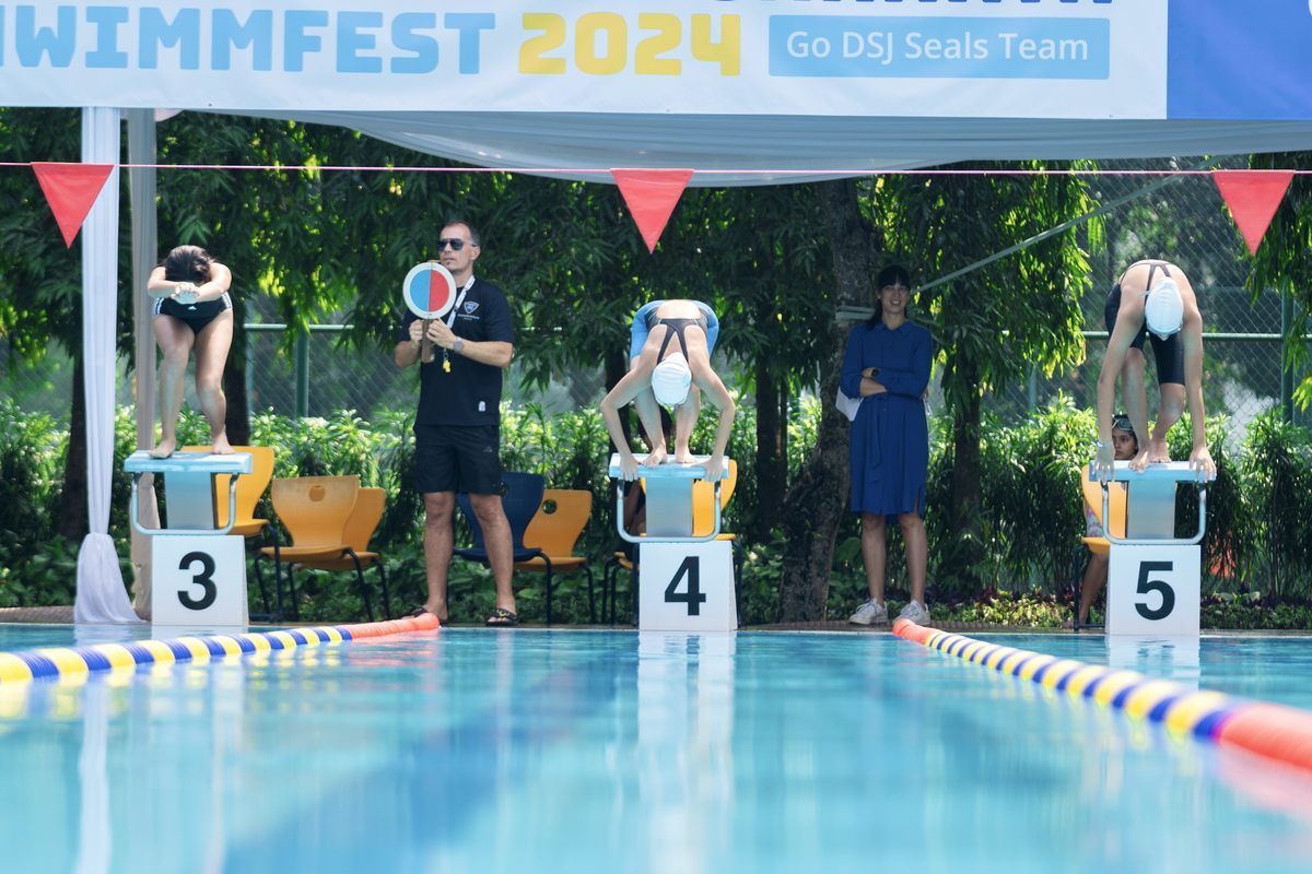 A group of people are getting ready to swim in a pool.