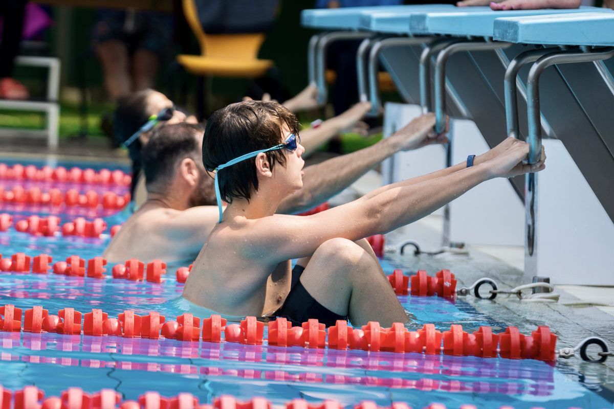 A group of young men are swimming in a pool.