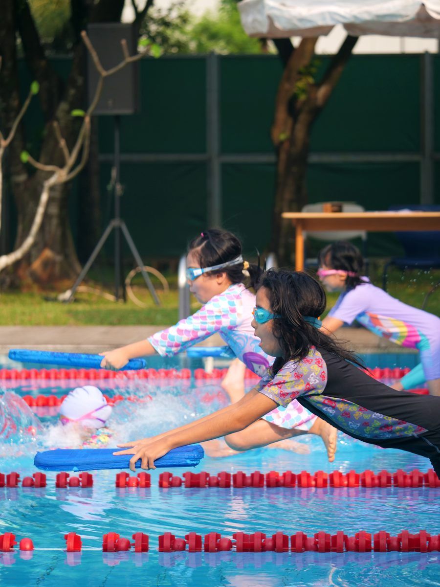 A group of children are swimming in a swimming pool.