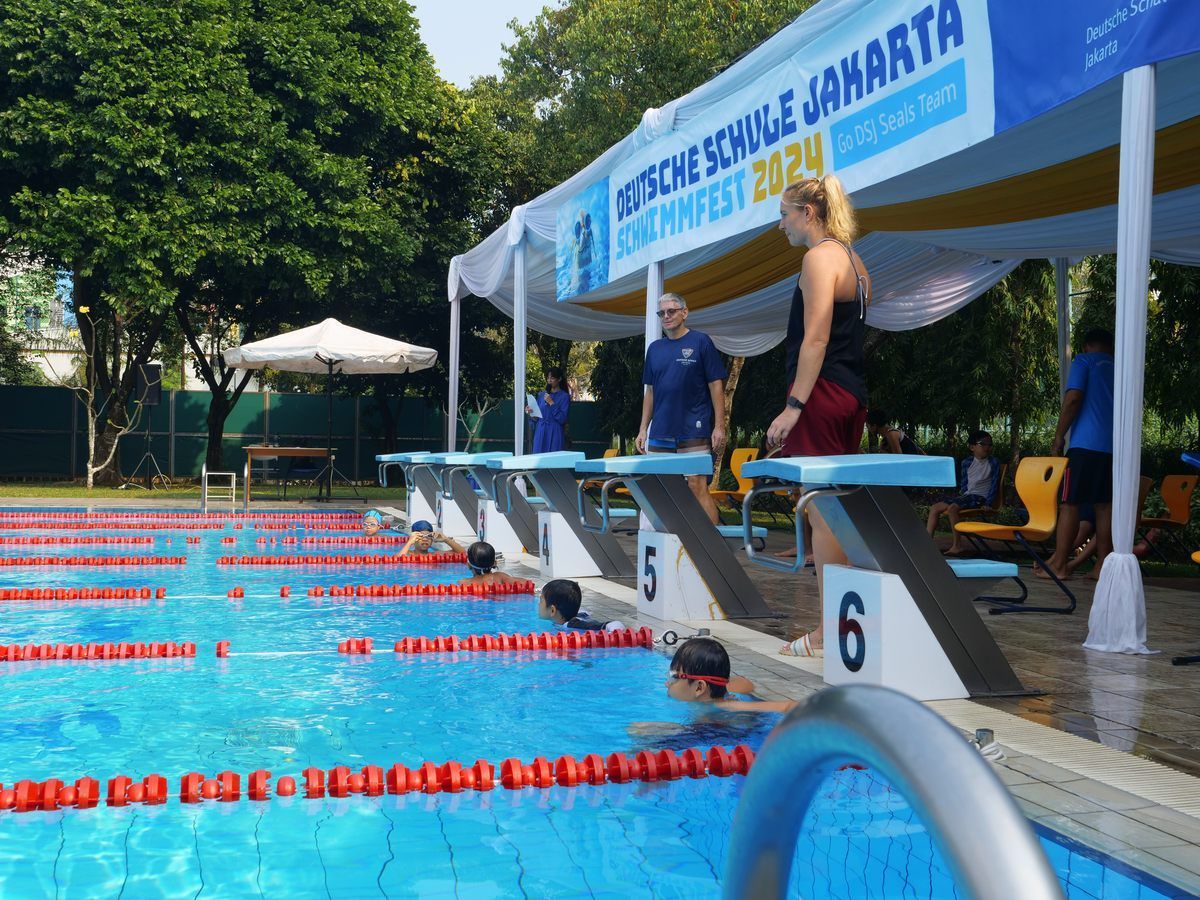 A group of people are swimming in a swimming pool.