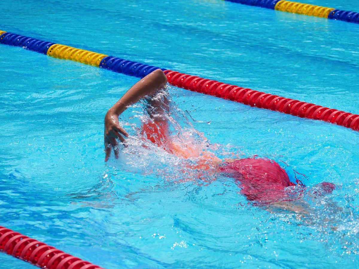 A person is swimming in a swimming pool.
