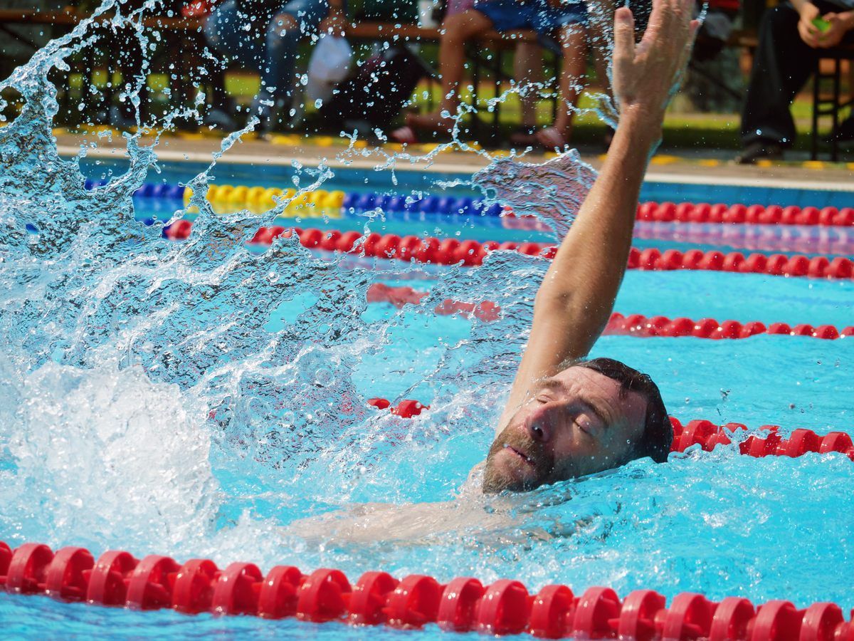 A man is swimming in a pool with red lanes