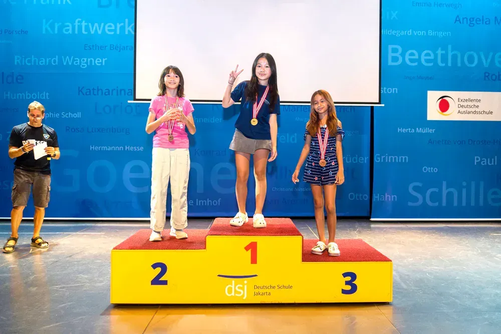 A group of young girls standing on a podium with the number 1 2 and 3 on it