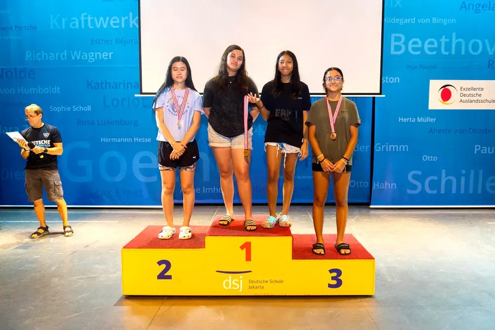 A group of girls standing on a podium with the number 1 2 and 3 on it