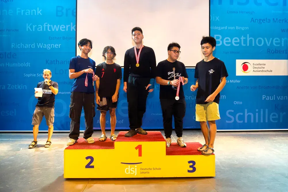 A group of young men standing on a yellow podium with the number 1 on it