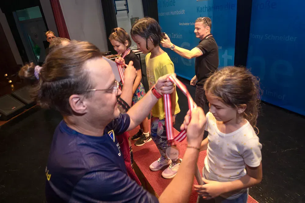 A man is giving a medal to a little girl.