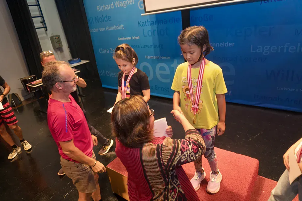 A group of people are standing around a table with medals around their necks.