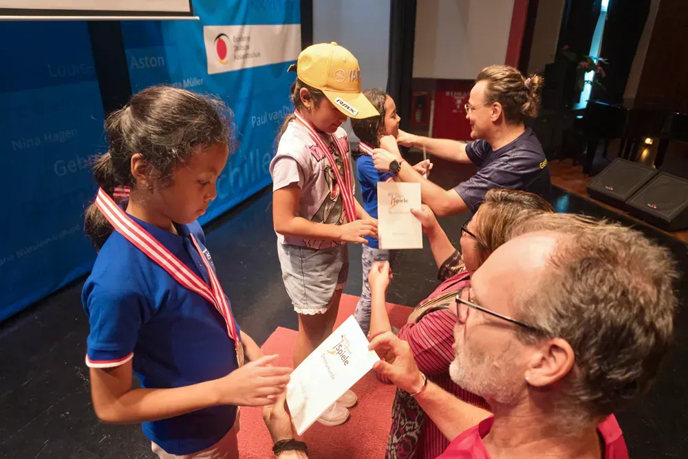 A man is giving a medal to a young girl.