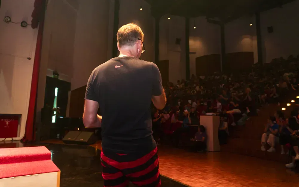A man is standing on a stage in front of a crowd.