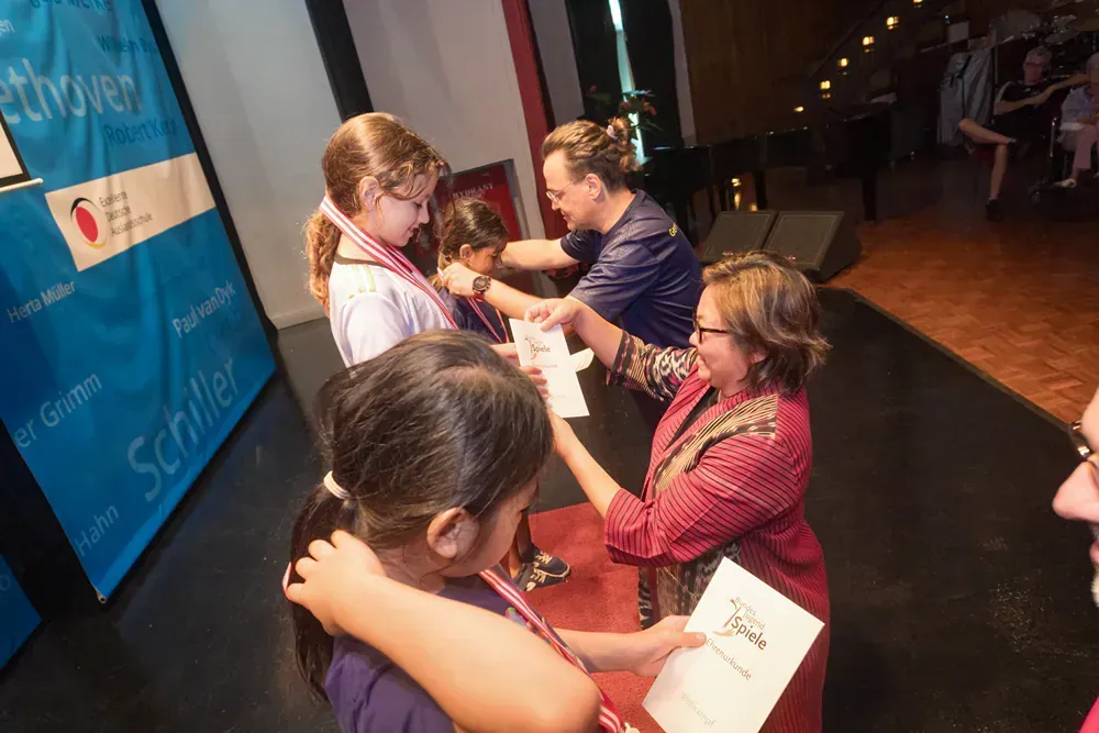 A woman is giving a medal to a young girl.