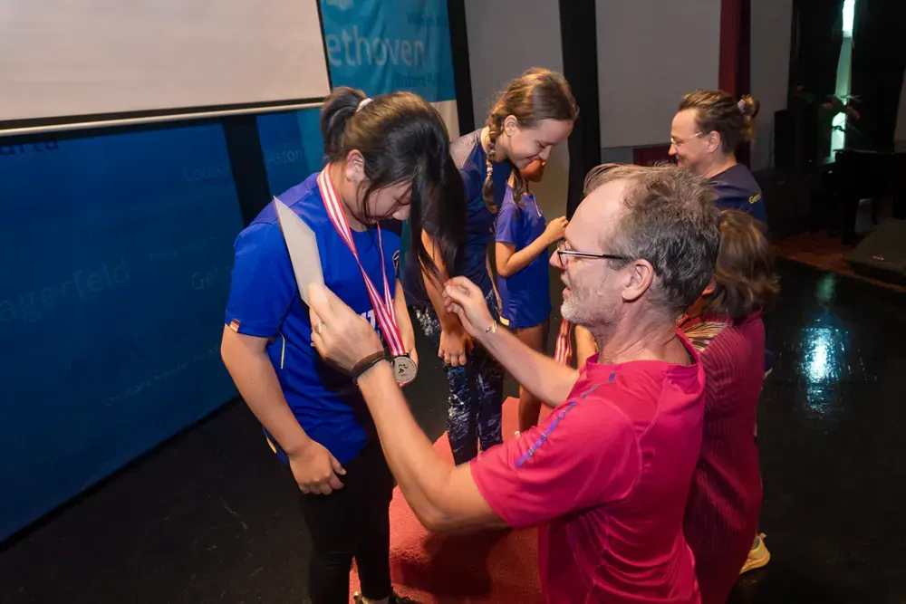 A man is putting a medal on a woman 's neck.