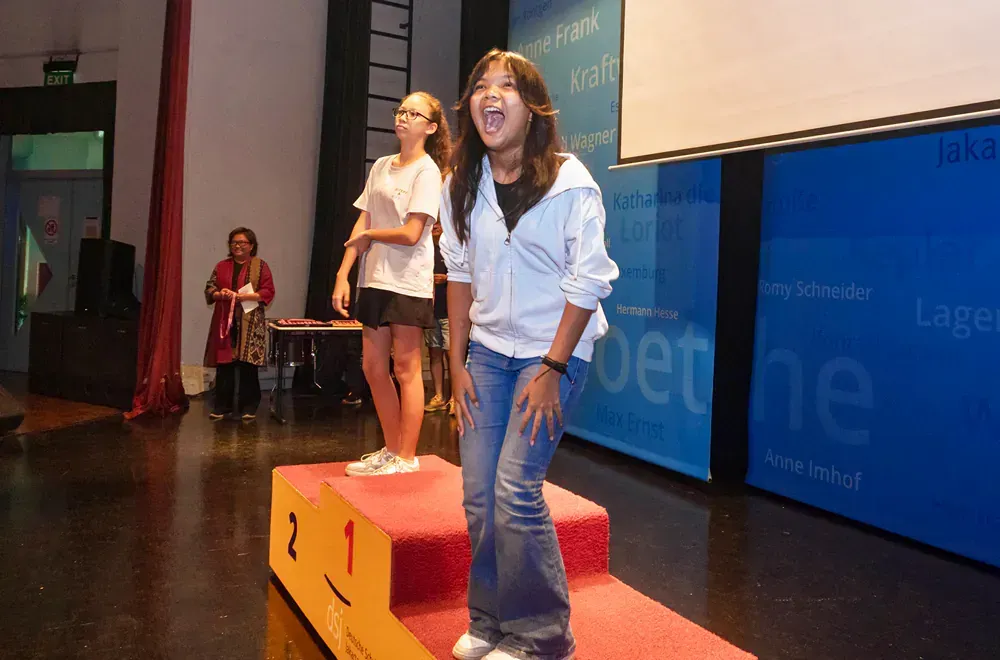 A girl stands on a podium with the number 2 on it