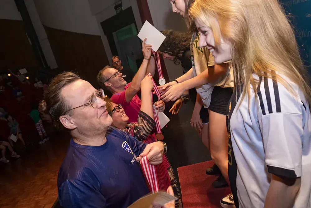 A man is giving a medal to a young girl.