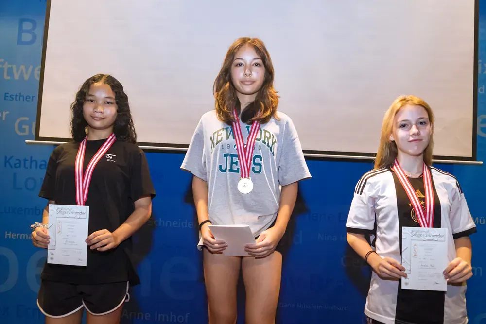 Three girls are posing for a picture and one of them is wearing a new york jewish shirt