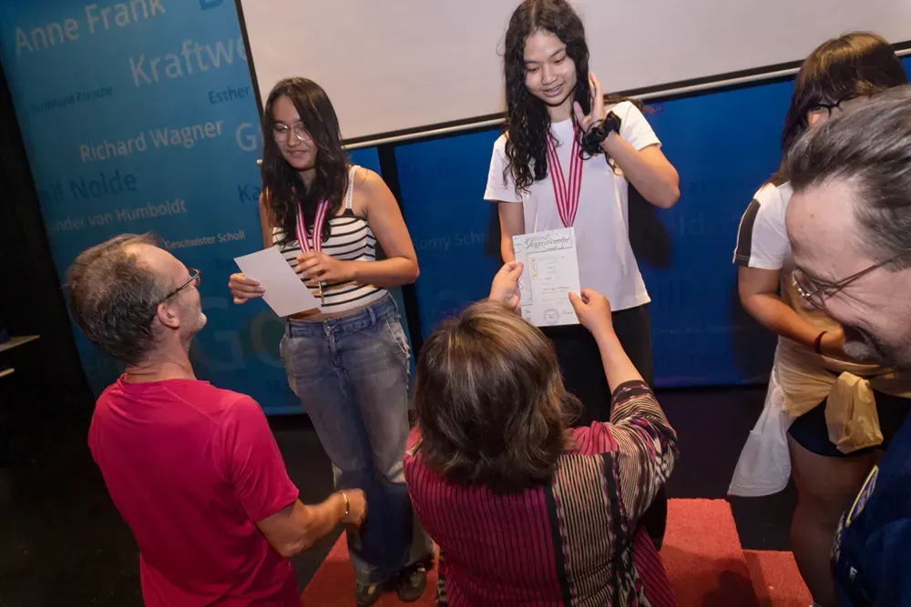 A group of people are standing around a man holding a piece of paper.