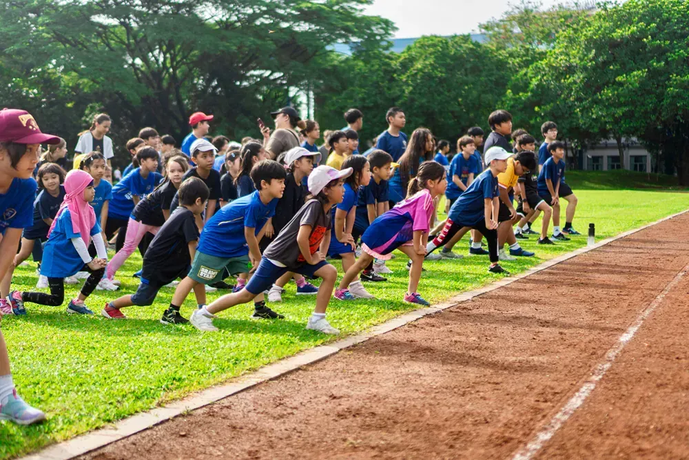 A group of children are getting ready to run on a track.