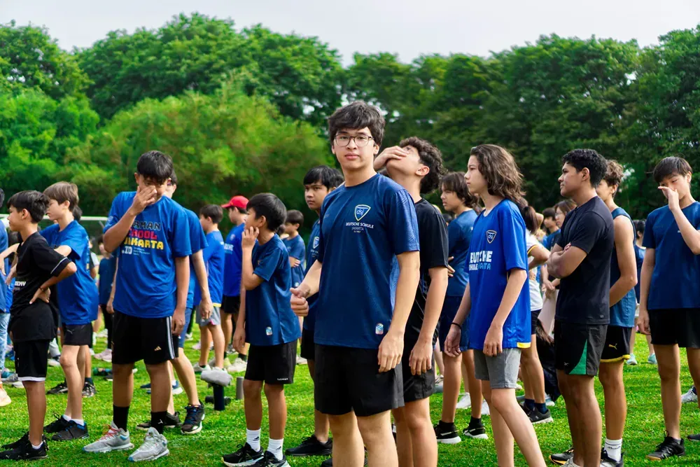 A group of young boys are standing in a field.