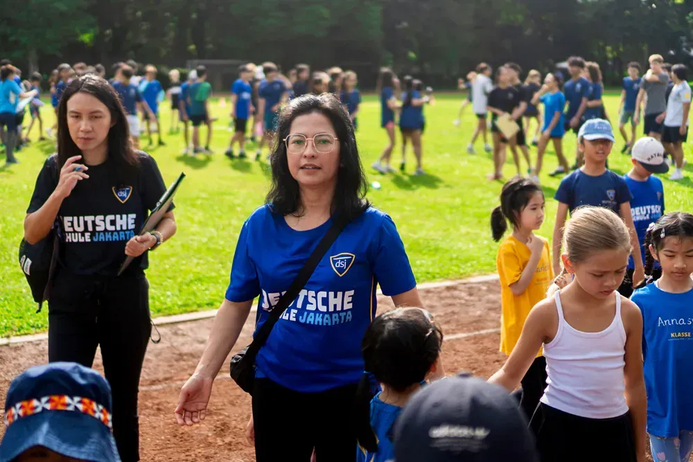 A woman in a blue shirt with the word deutsche on it