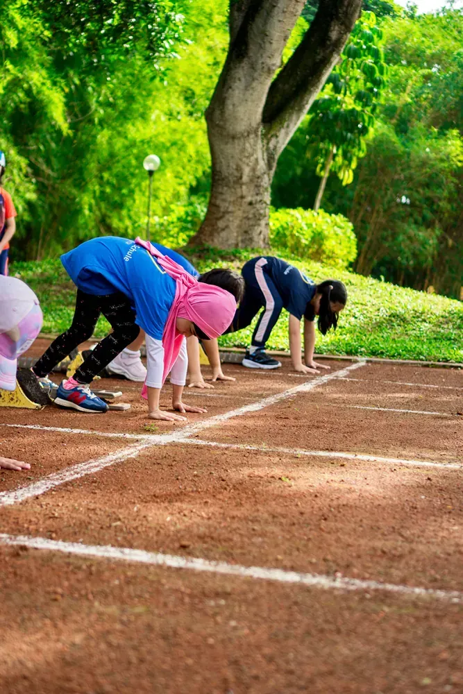 A group of children are getting ready to run on a track.
