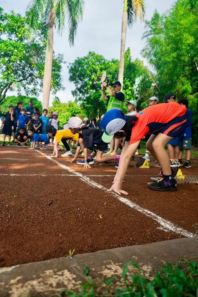 A group of children are doing a handstand on a track.