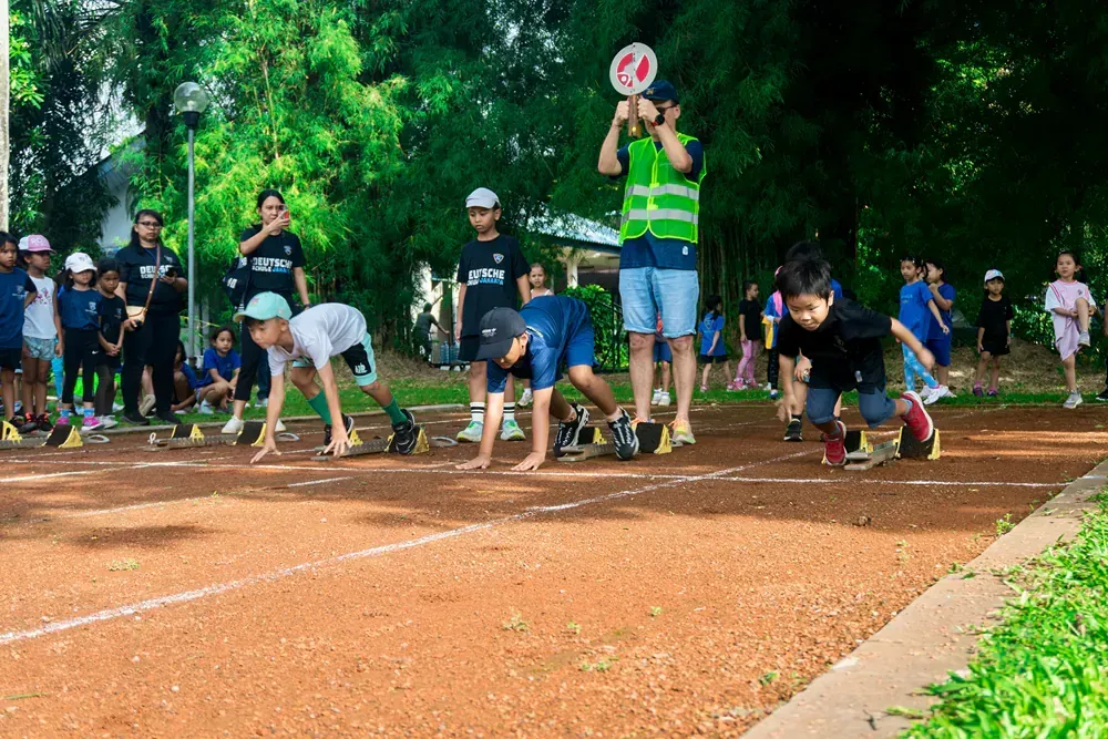 A group of children are getting ready to run on a track.