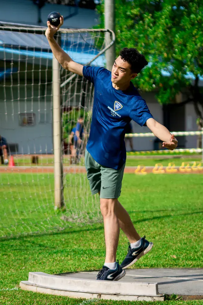 A young man is throwing a ball in a field.