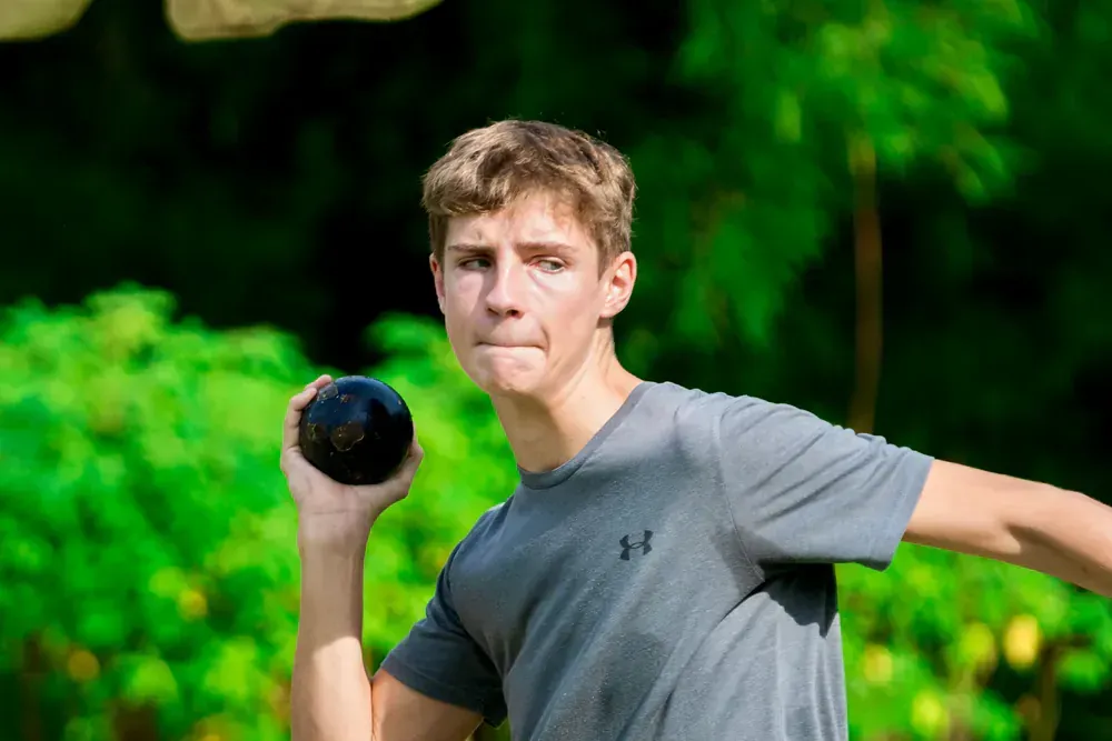 A young man is throwing a frisbee in the air.