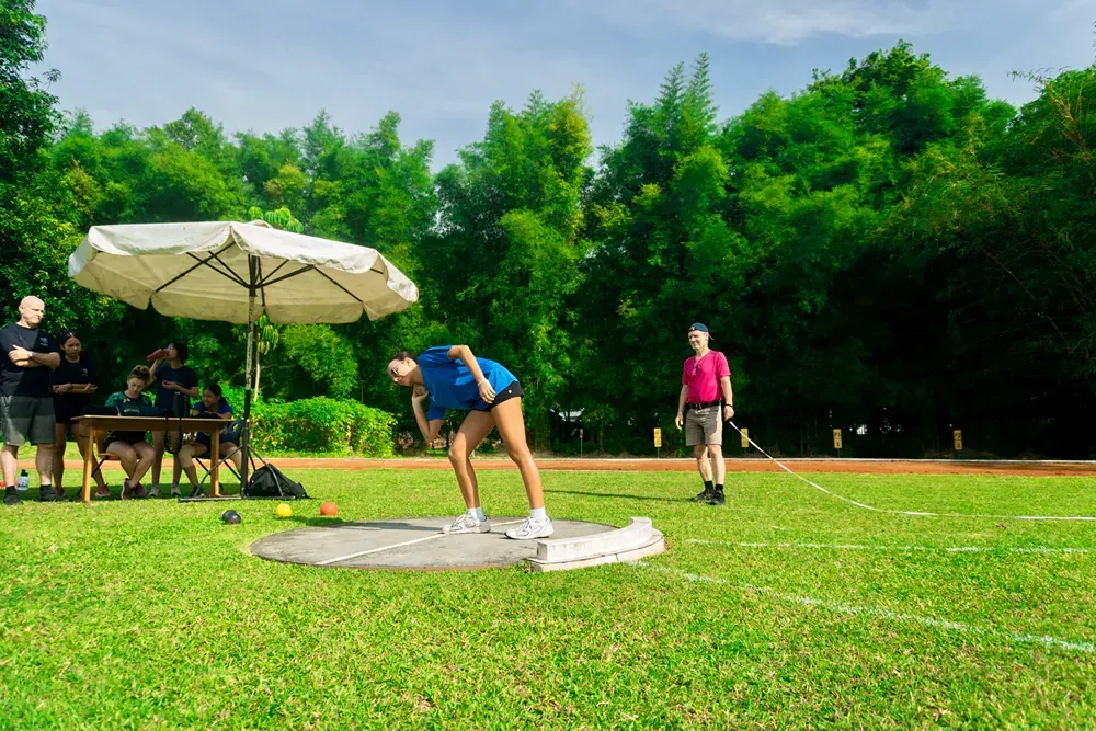 A woman is throwing a frisbee in a field.