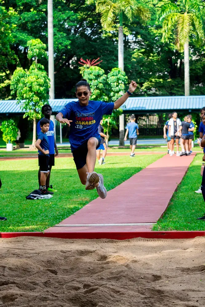 A man is jumping in the air while a group of people watch.