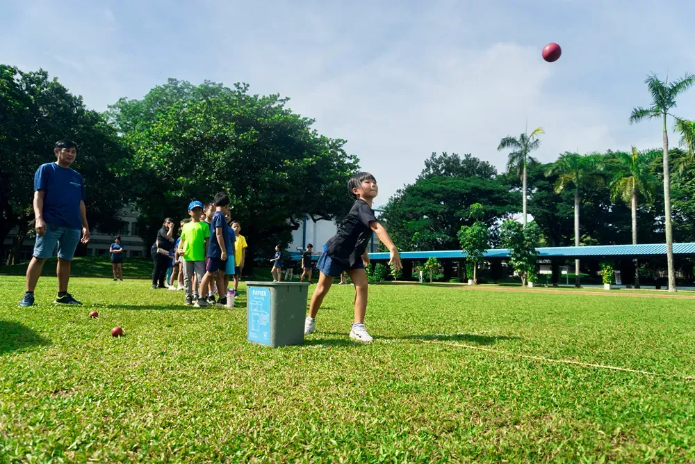 A group of children are throwing a ball in a field.