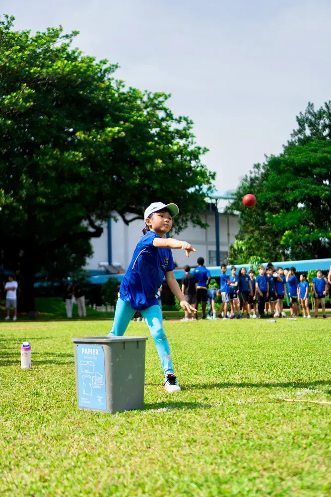A young boy is throwing a ball in a field.