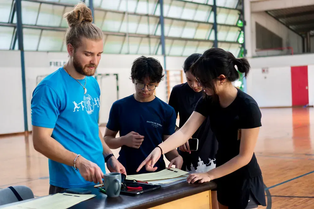 A group of people are working on a project in a gym.