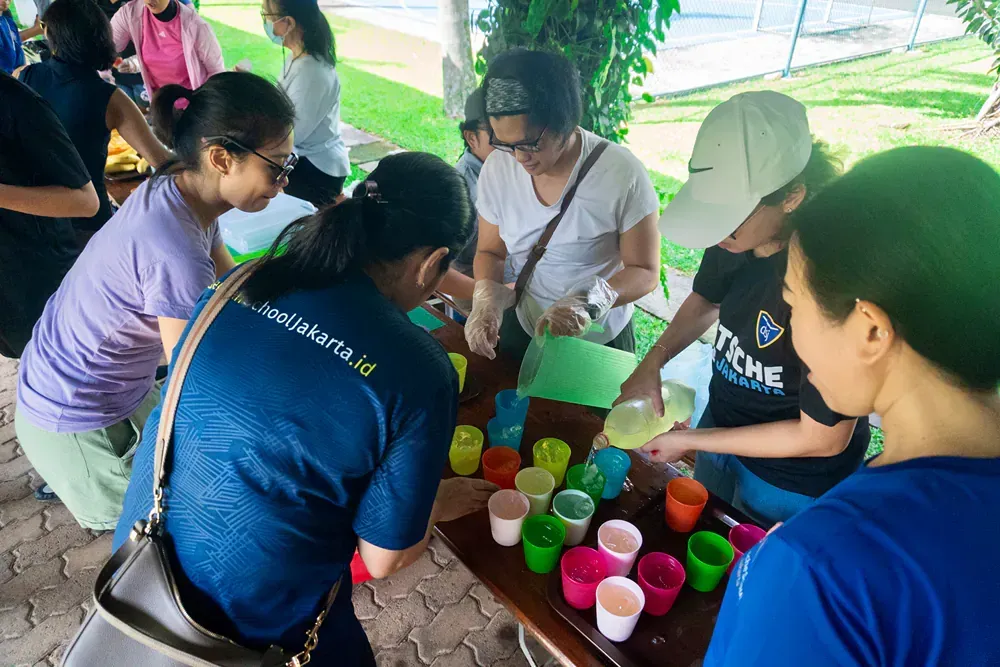 A group of people are sitting around a table with cups on it.