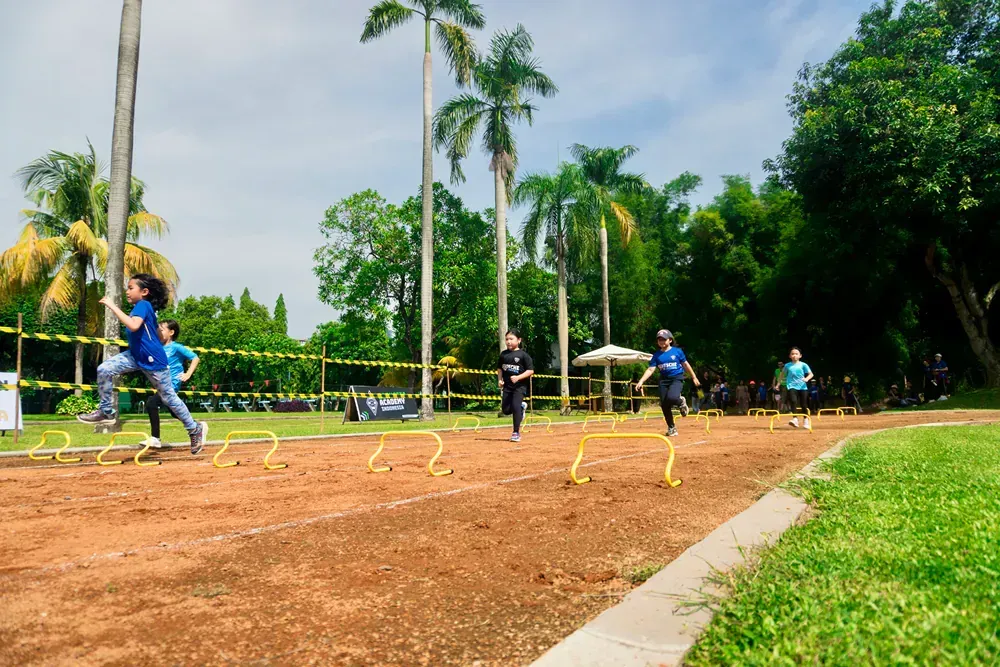 A group of people are running on a dirt track.