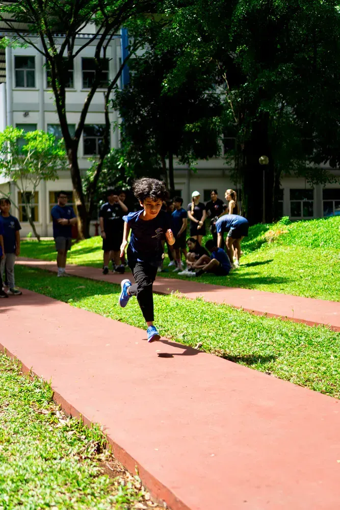 A group of people are running on a track in a park.