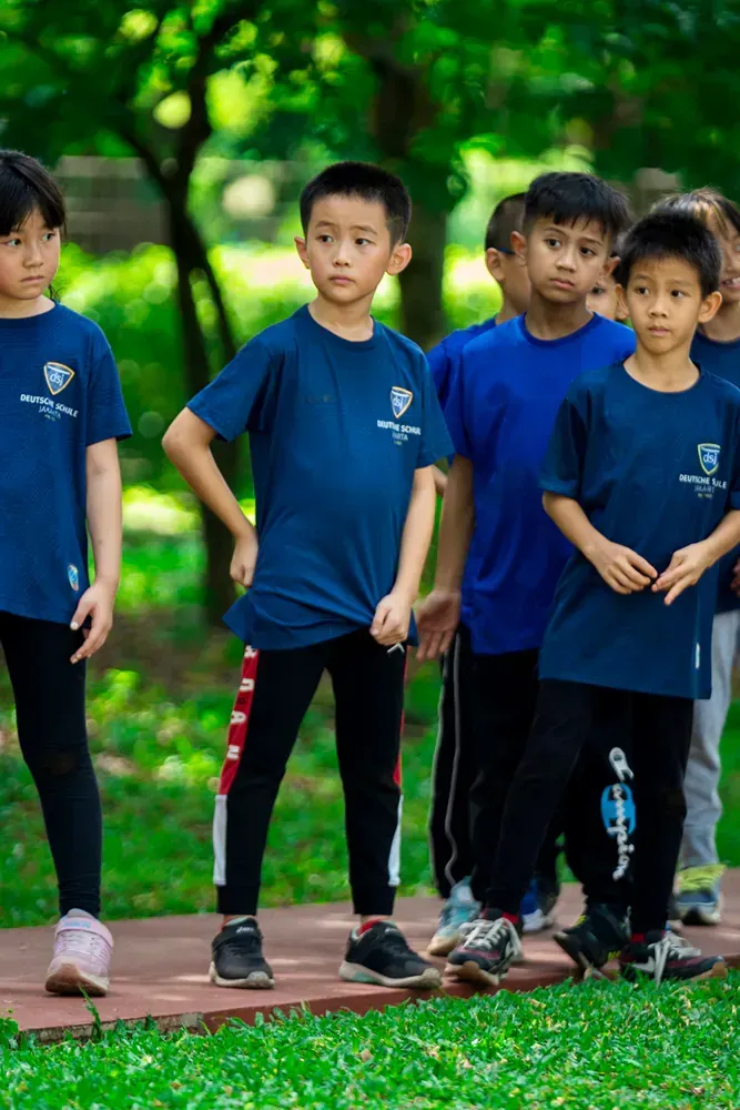 A group of children are standing next to each other in a park.
