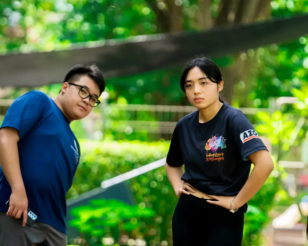 A man and a woman are standing next to each other in a park.