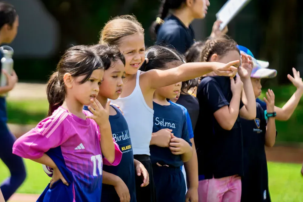 A group of young girls are standing next to each other on a field.