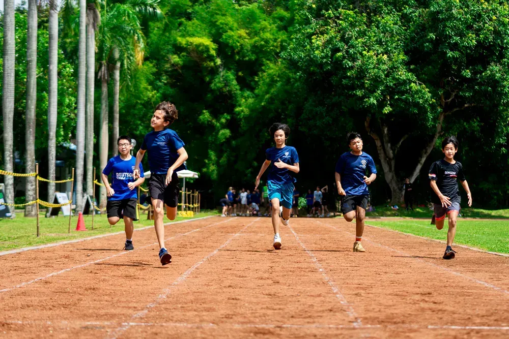 A group of children are running on a track.