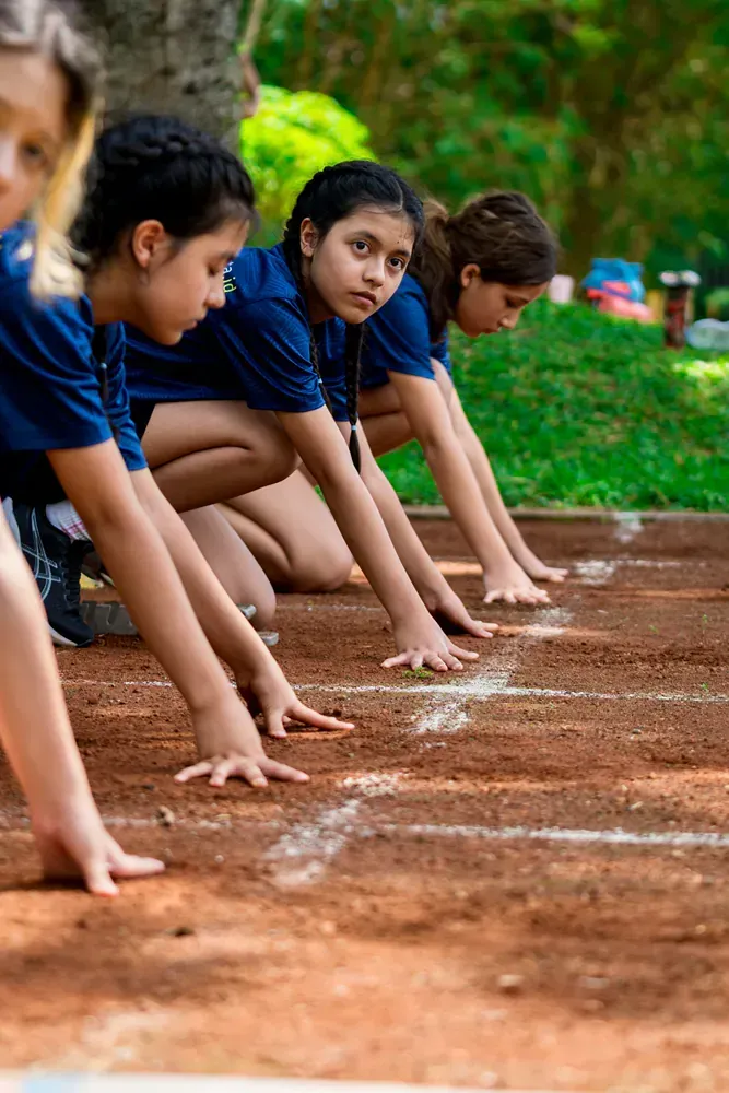 A group of young girls are getting ready to run on a track.