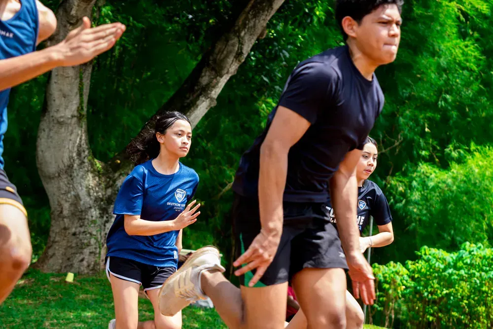 A group of young people are running in a park.