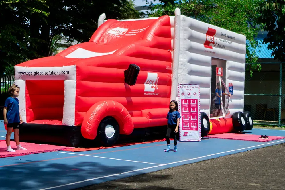 A girl is standing in front of a large inflatable truck.