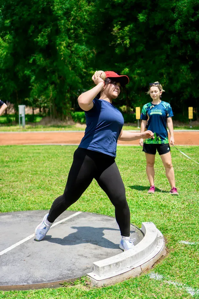 A woman is throwing a discus on a track.