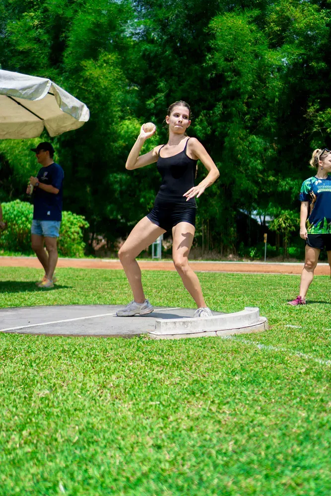 A woman is throwing a discus in a field.