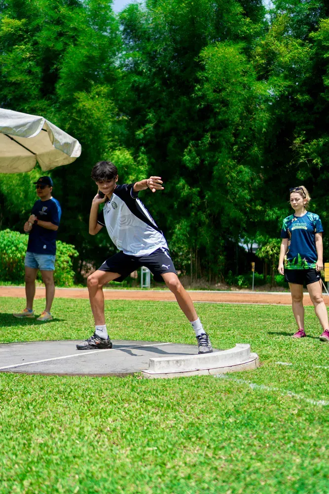 A man is throwing a discus in a field.