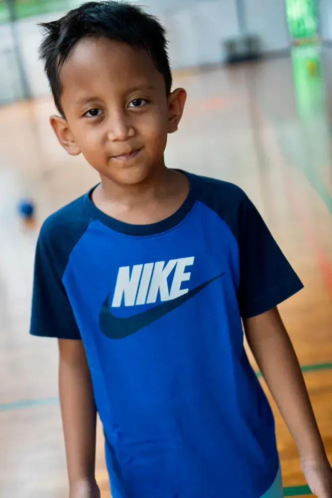 A young boy is wearing a blue nike shirt